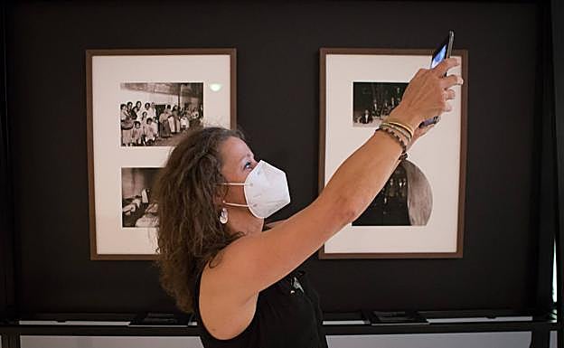 Una mujer graba con su móvil unos planos de la exposición 'Nocturnas', inaugurada ayer. 