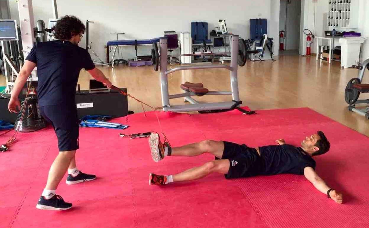 Un deportista trabaja a las órdenes de su preparador físico.