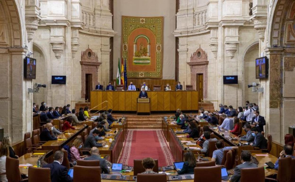 El presidente andaluz, Juanma Moreno (c), durante su intervención hoy en el Parlamento andaluz