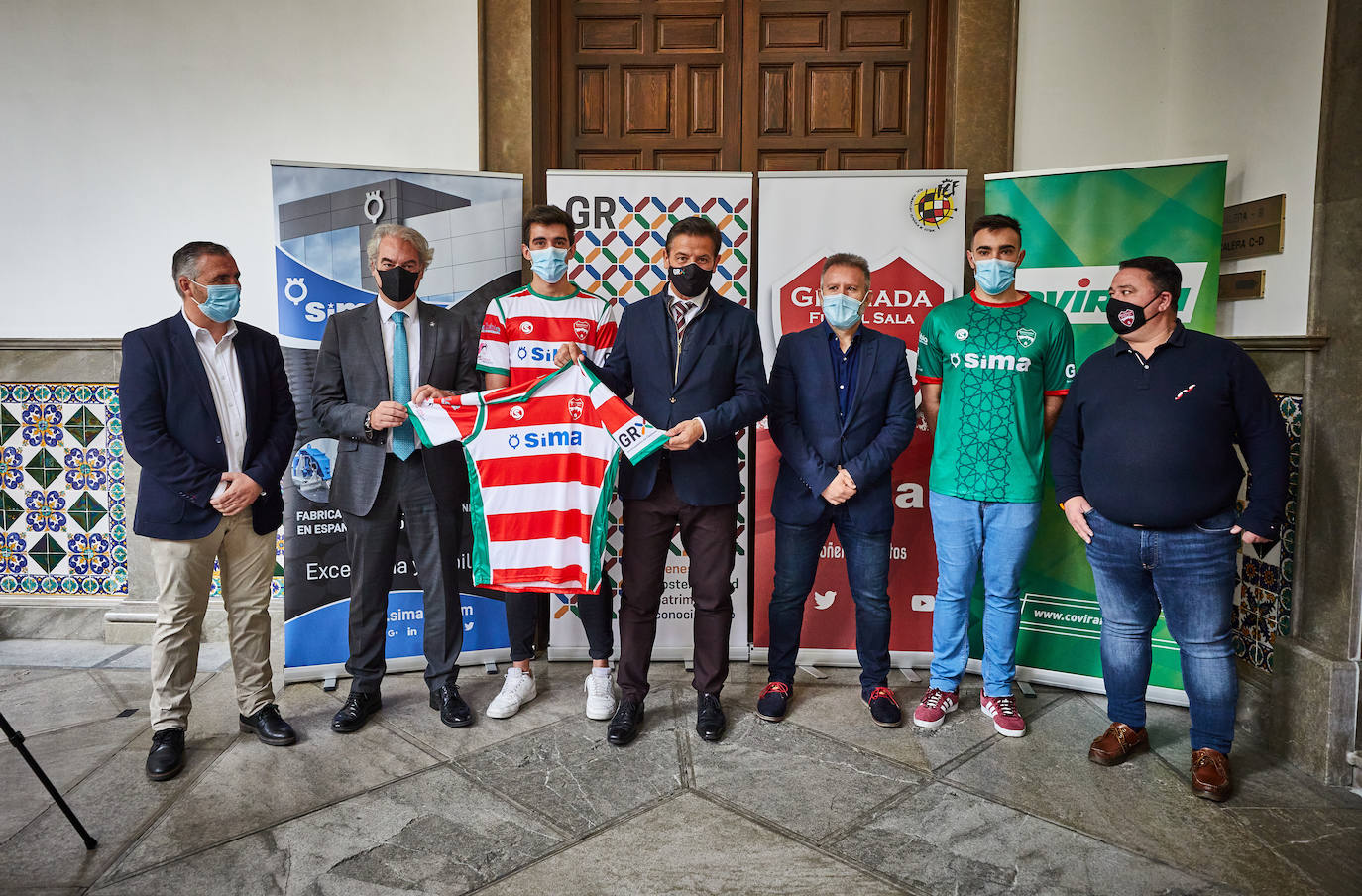 Las autoridades involucradas en el acto de presentación del Sima Granada posan junto a las dos equipaciones del club. 