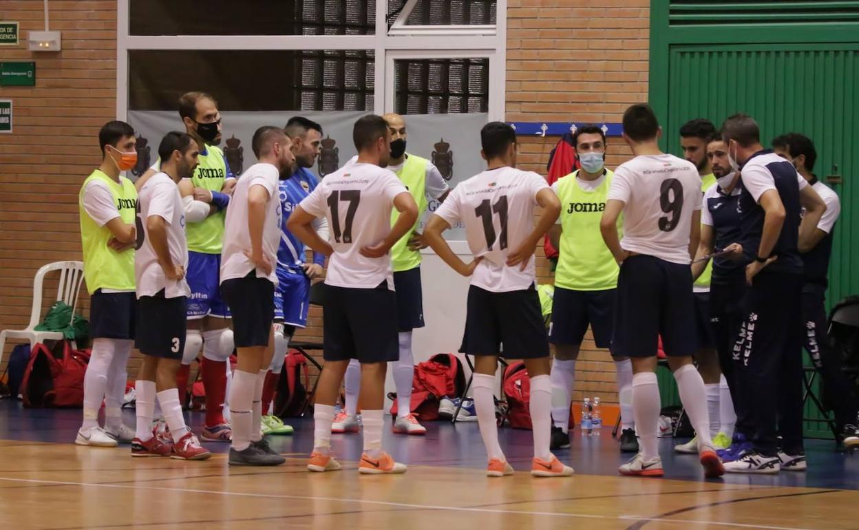 Los jugadores del Sima Granada escuchan con atención las indicaciones de su entrenador. 