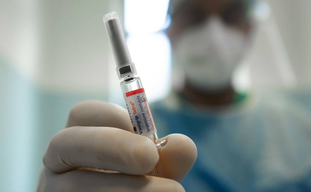 Un profesional sanitario sostiene una vacuna.