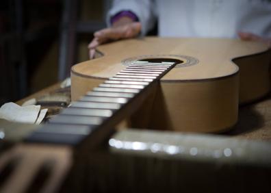 Imagen secundaria 1 - Arriba, analizando una guitarra. Abajo, detalle de un instrumento y Ana lijando. 