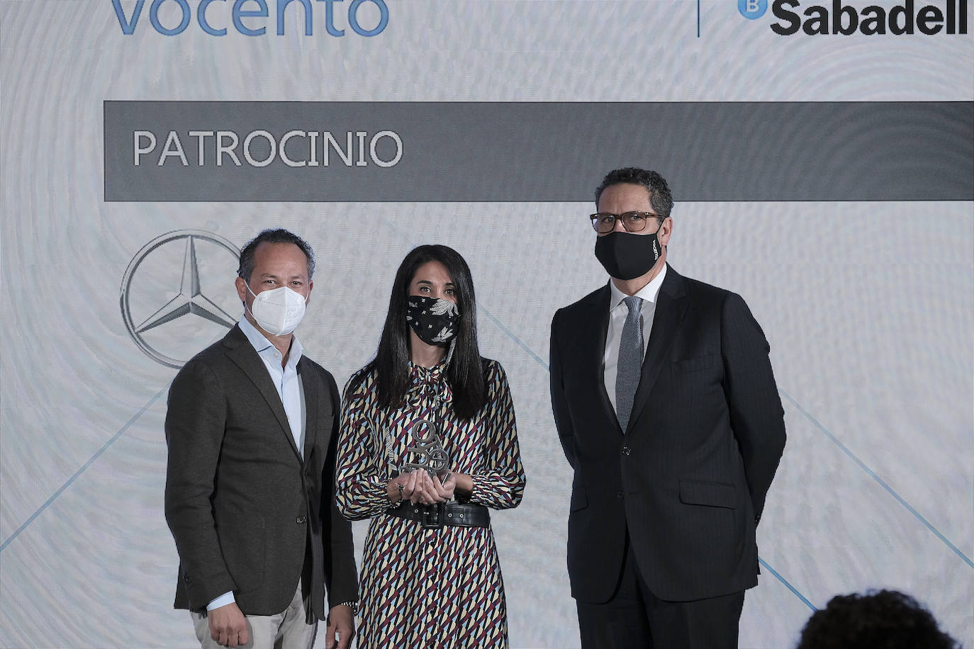 Rafael Martínez de Vega, director general de CMVocento, entrega el premio a Benito Jiménez, director de marketing de Mercedes-Benz, y Marta García, resaponsable de MBFW Madrid.