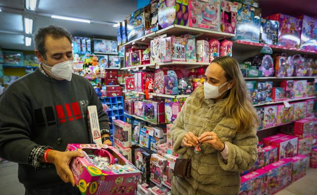 Eduardo Valverde muestra unos juguetes a una clienta que quiere comprobar que están bien escritos en la carta a los Reyes Magos. 