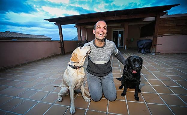Los perros guía Saúl y Halley, con su amo, en la terraza de su casa de Albolote. 