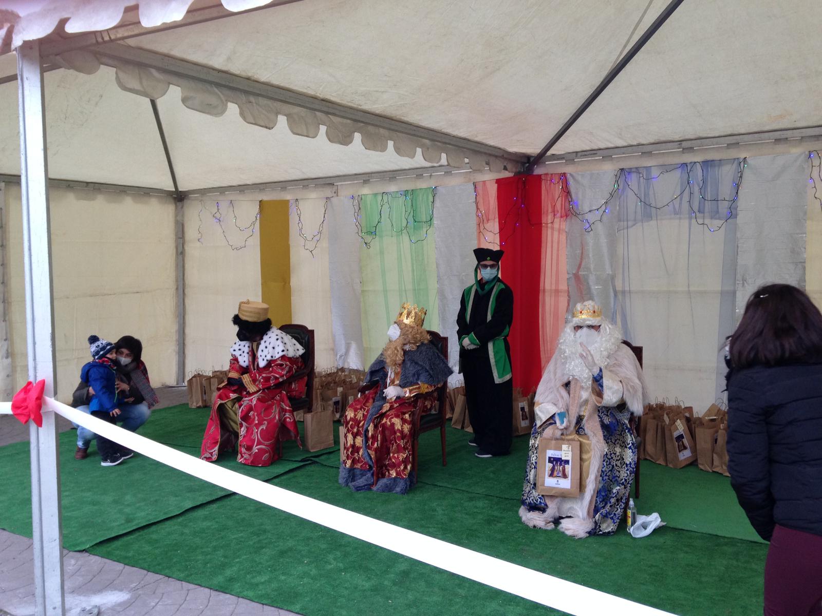 Un niño muestra su ilusión en Monachil al ver a los Reyes, que llevaban su mascarilla puesta.