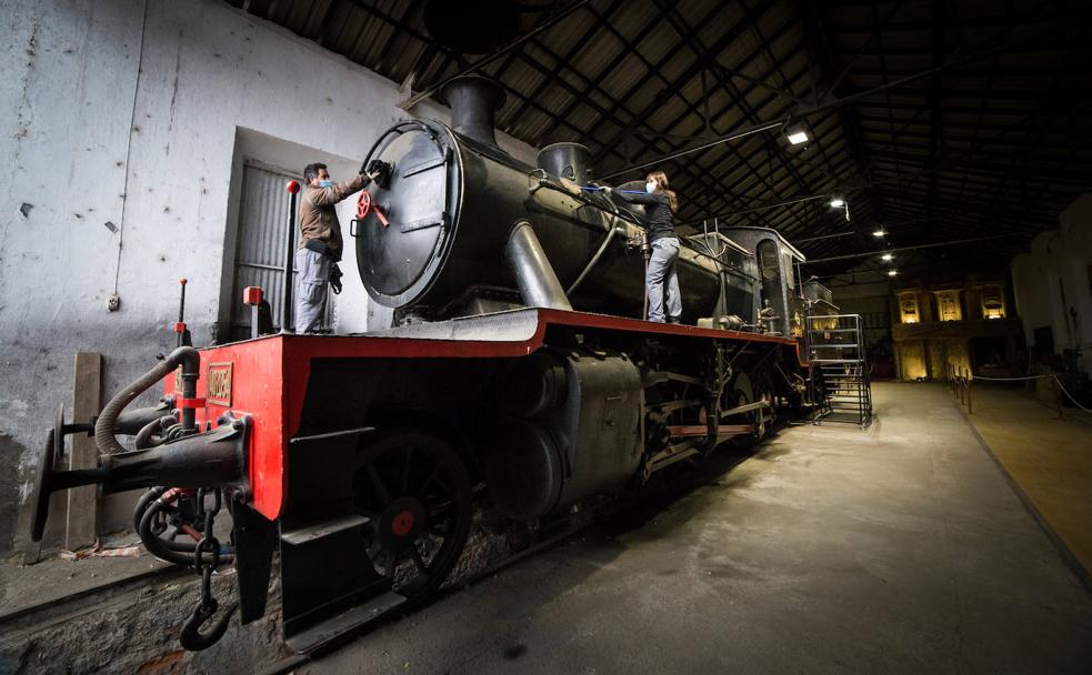 Dos operarios del Ayuntamiento, José y Andrea, trabajan en la limpieza de la locomotora y el ténder en el cocherón de la estación de Guadix donde está al resguardo. 