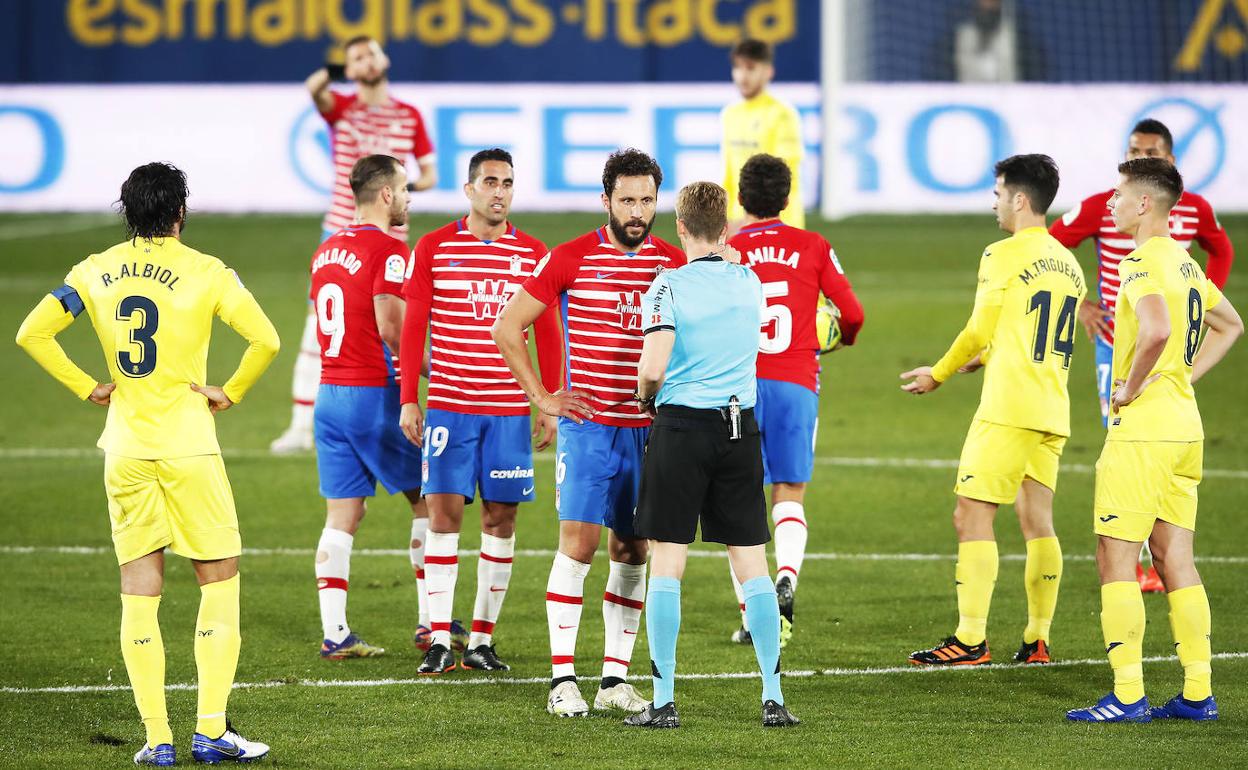 Los futbolistas del Granada piden explicaciones a Pizarro Gómez tras una de sus decisiones. 