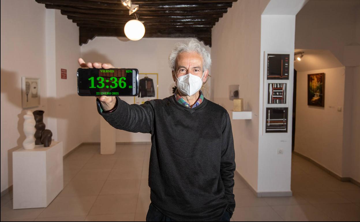 Javier Arrabal, de Arrabal & Cía, muestra la hora en el reloj de su móvil.
