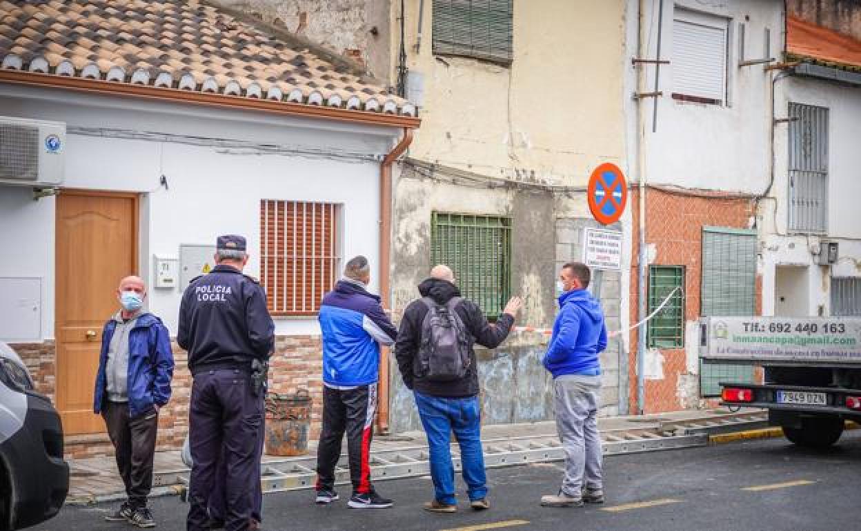 Vecinos de Santa Fe junto a un policía local observan los daños en una vivienda.