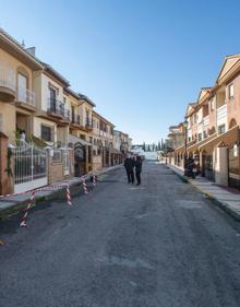 Imagen secundaria 2 - Julia y su padre muestran las rajas en la pared del salón de su vivienda, donde han bajado los colchones para dormir más seguros. Una vista de la calle Olivares de Atarfe, donde viven.