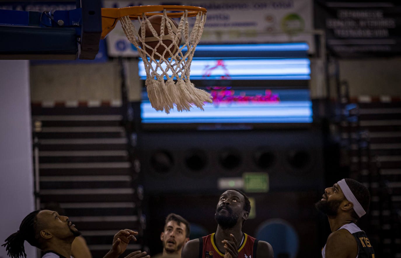 Bamba Fall, en el centro, observa al balón dentro de la cesta en un tiro libre.