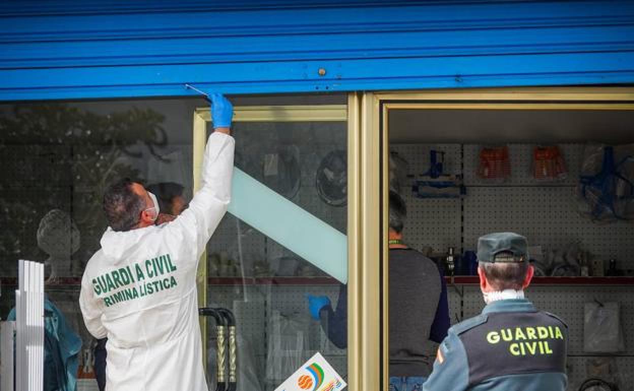 Agentes de la Guardia Civil recogen pruebas del interior del negocio donde sucedieron los hechos ayer, en el Polígono de Juncaril de Albolote
