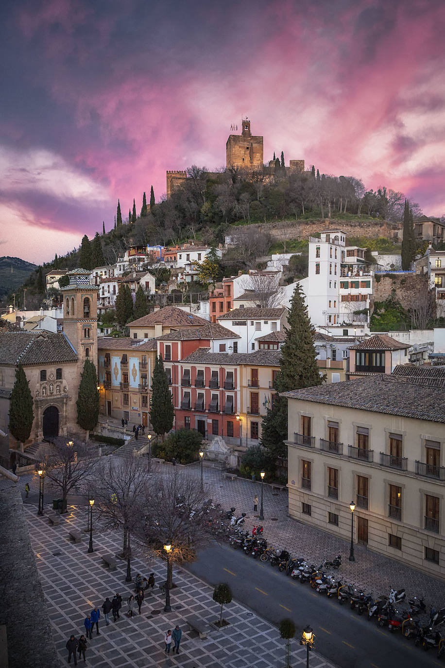 La Torre de la Vela justo al atardecer, con la luz incidiendo sobre las nubes rosadas. 