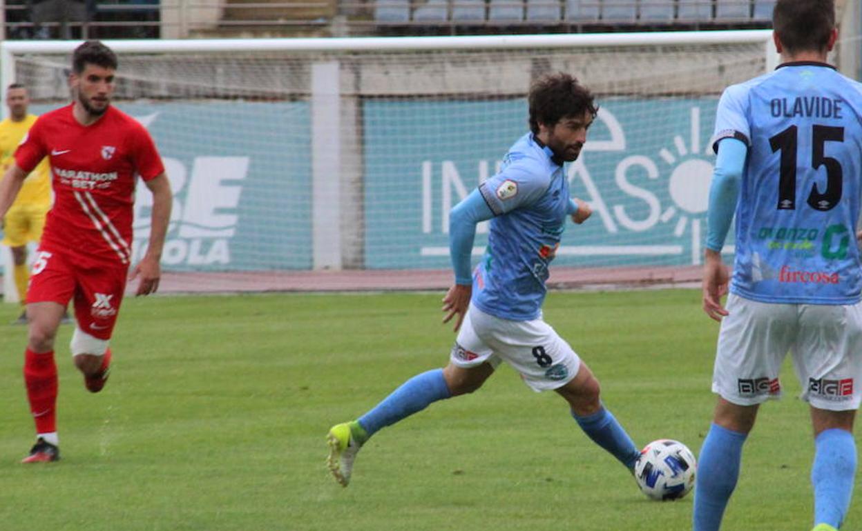 Víctor Pérez, con el número 8, avanza con el balón en el derbi ante el filial nervionense.