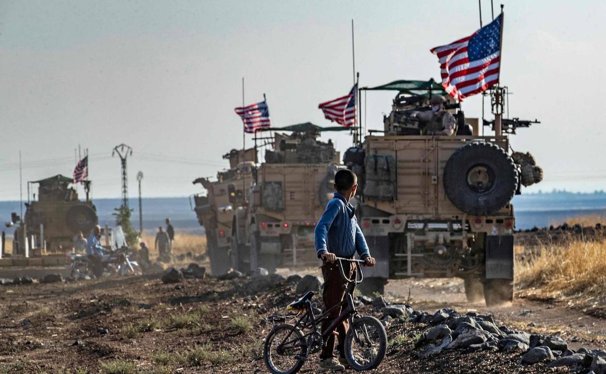 Un niño sirio observa un convoy de blindados de EE UU que patrullan cerca de la ciudad de Qahtaniyah.