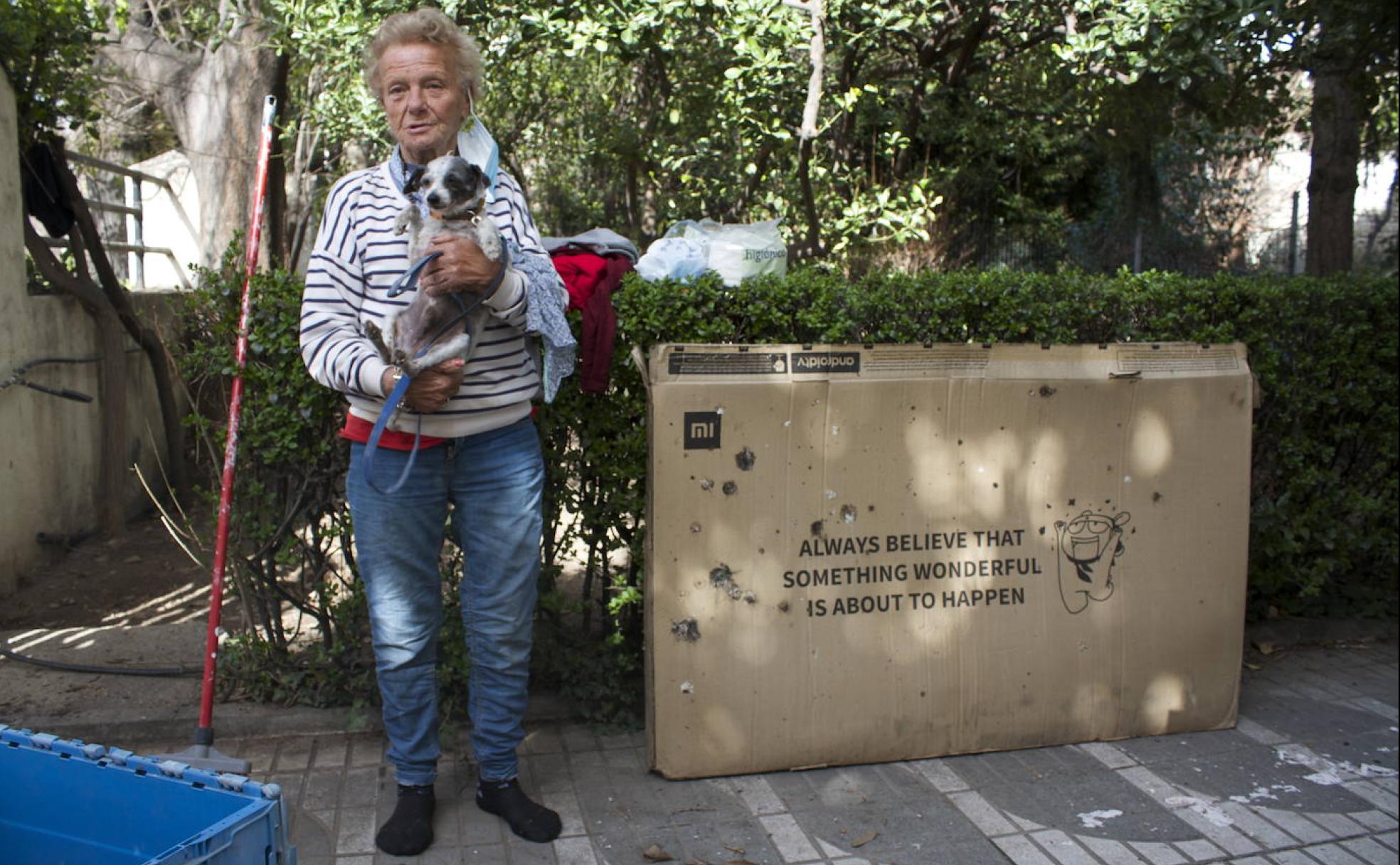 Isabel sostiene a Mariana junto a la caja que les sirve para protegerse por la noche. 