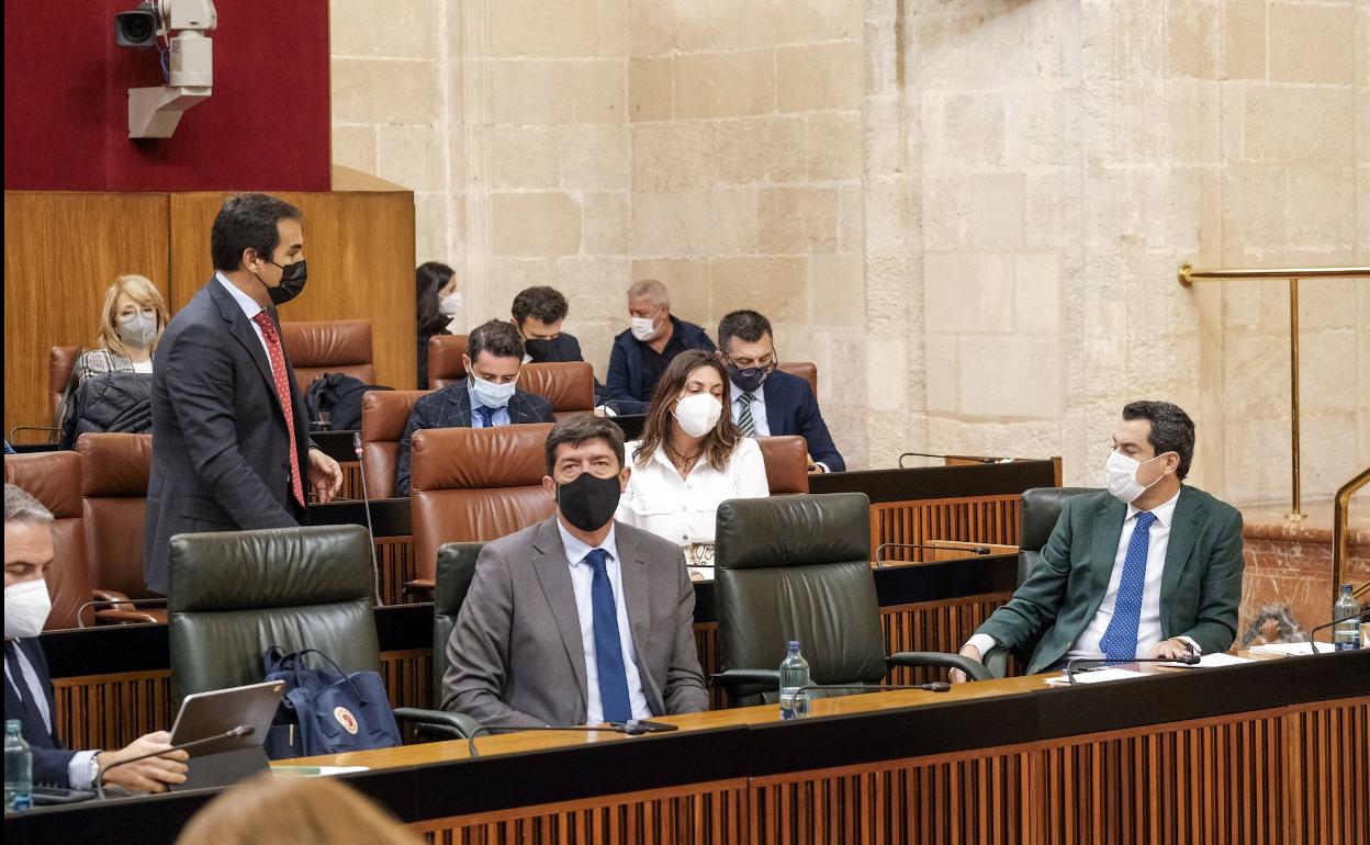 Juanma Moreno atiende a la pregunta del portavoz del PP, José Antonio Nieto, en presencia de Juan Marín.