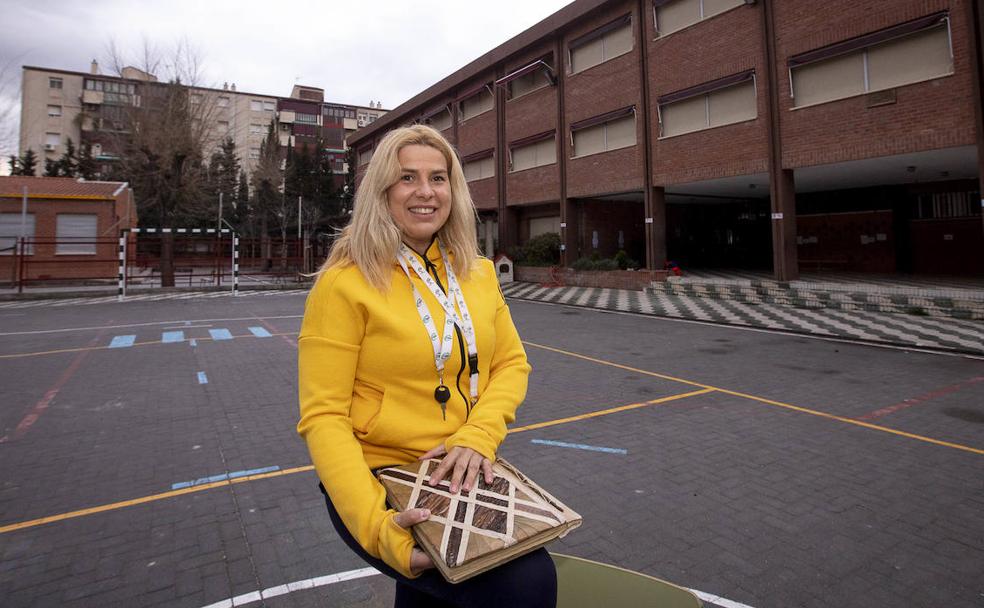 Irene posa con el álbum lleno de recuerdos en el patio de su colegio.