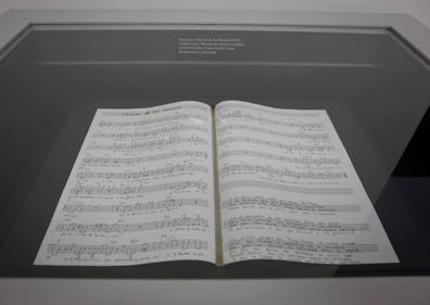 Imagen secundaria 1 - Arriba, peroles. Abajo, partitura con la canción 'Alacena de las monjas' de Carlos Cano y bocas de crema pastelera. 