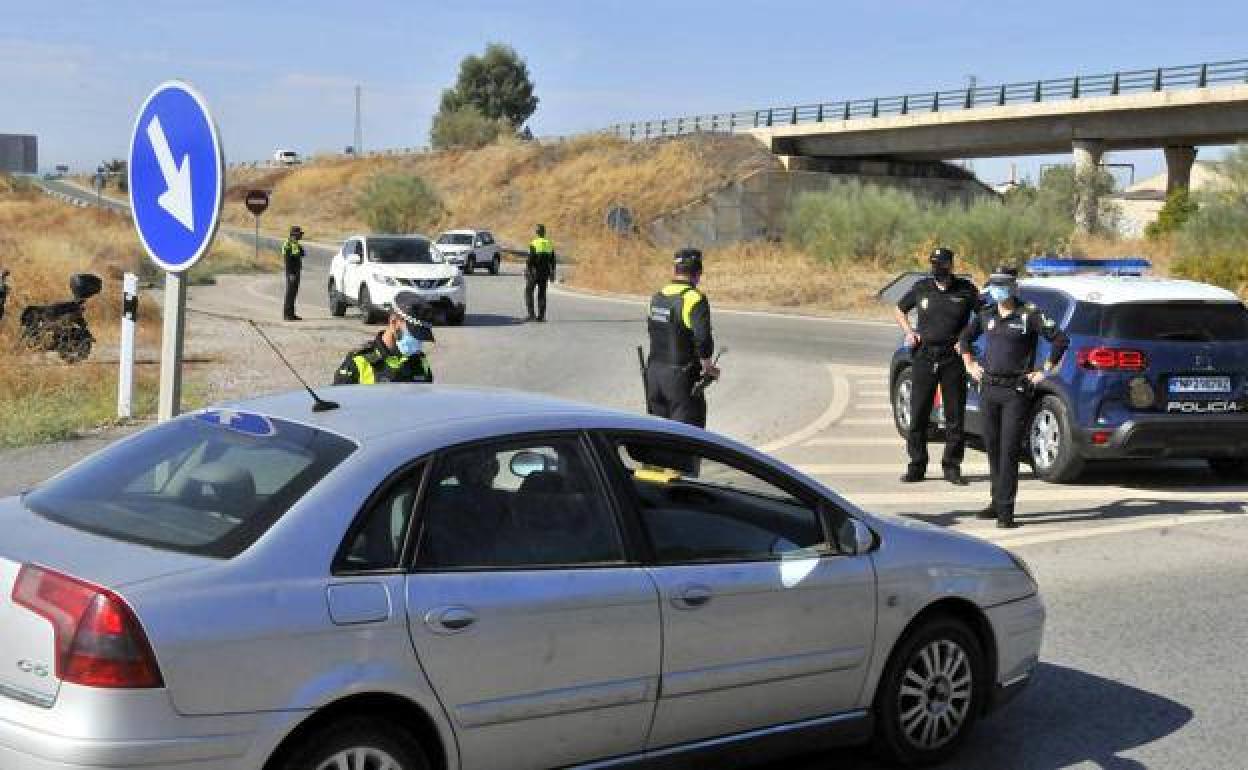Agentes de Policía Local y Nacional dan el alto a vehículos en uno de los accesos a la ciudad. de Linares durante el estado de alarma.. 