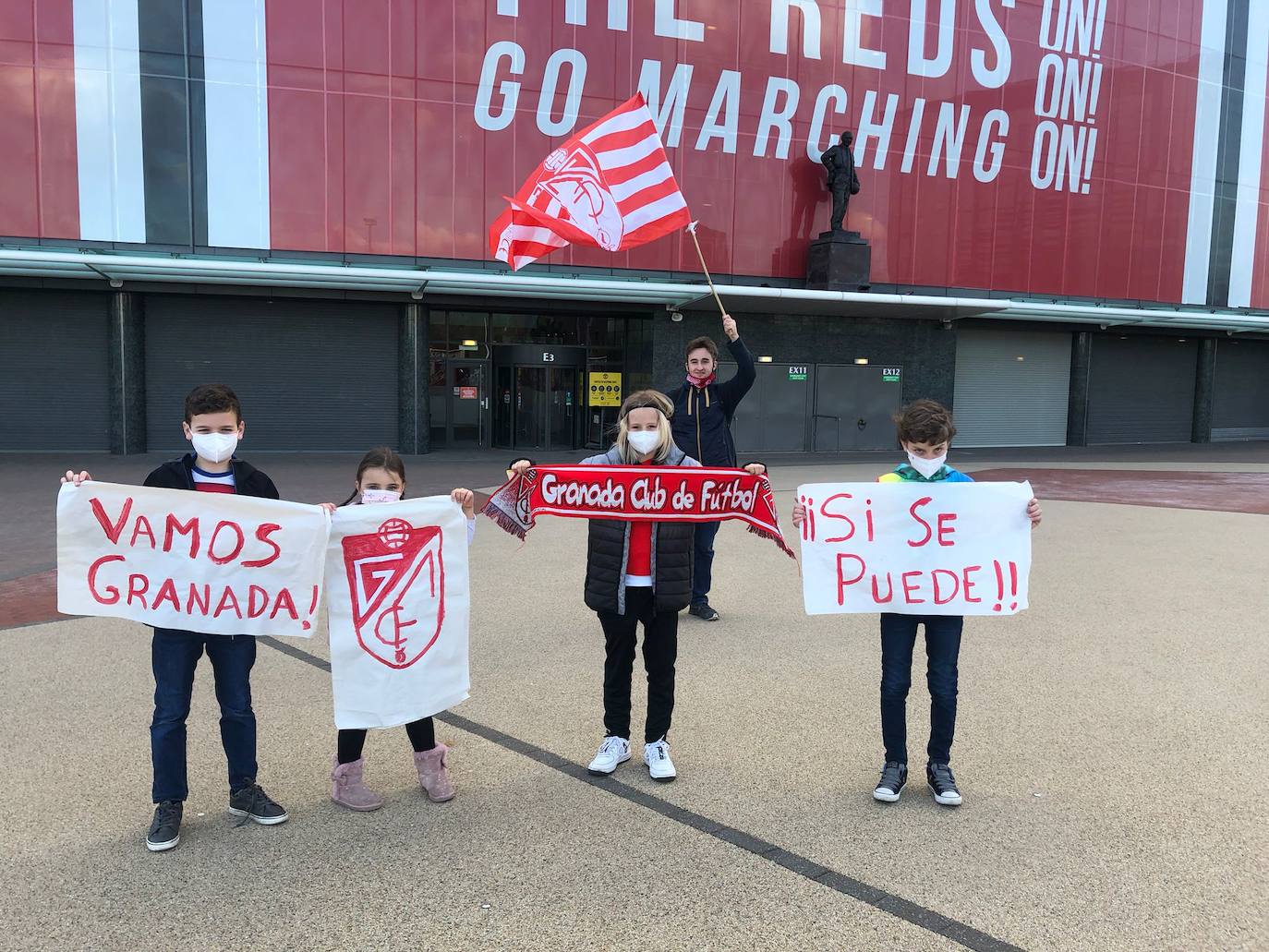 Los hijos de Teresa, junto a un amigo inglés, y Federico, atrás con la bandera, en los alrededores de Old Trafford. 