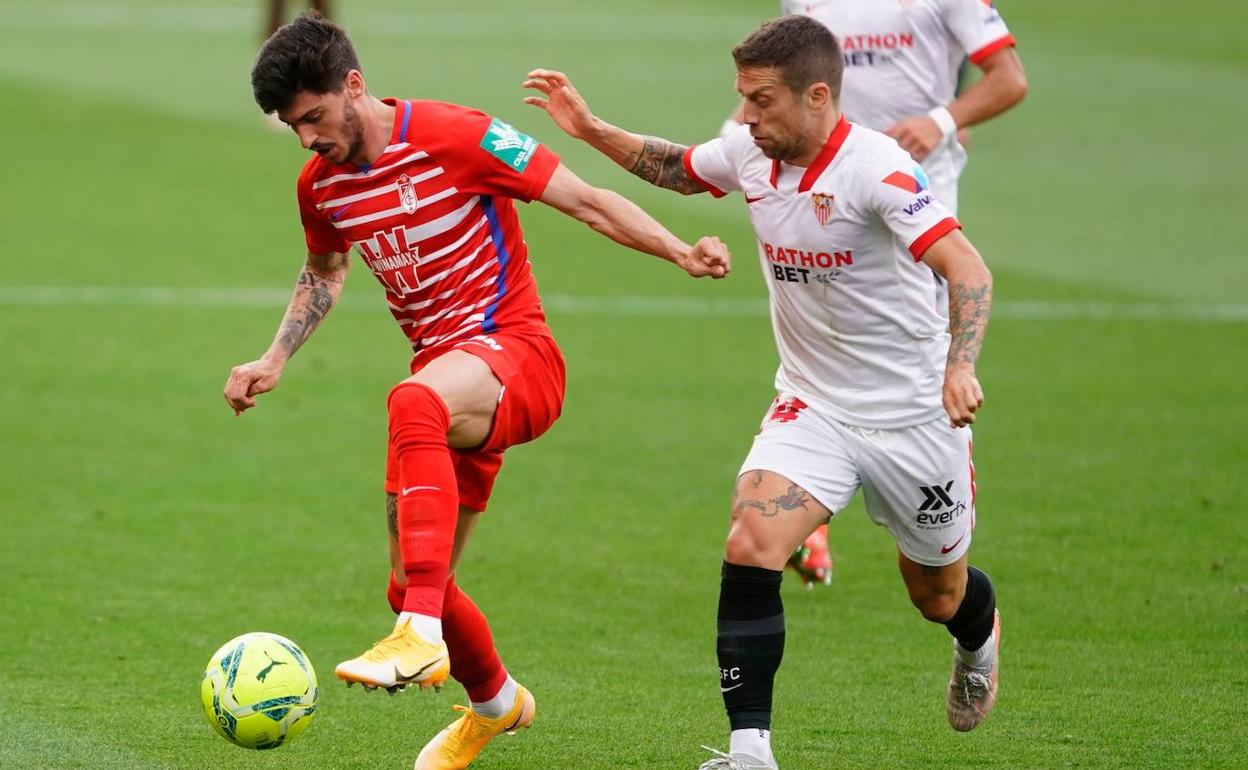 Carlos Neva controla un balón ante el Papu Gómez. 