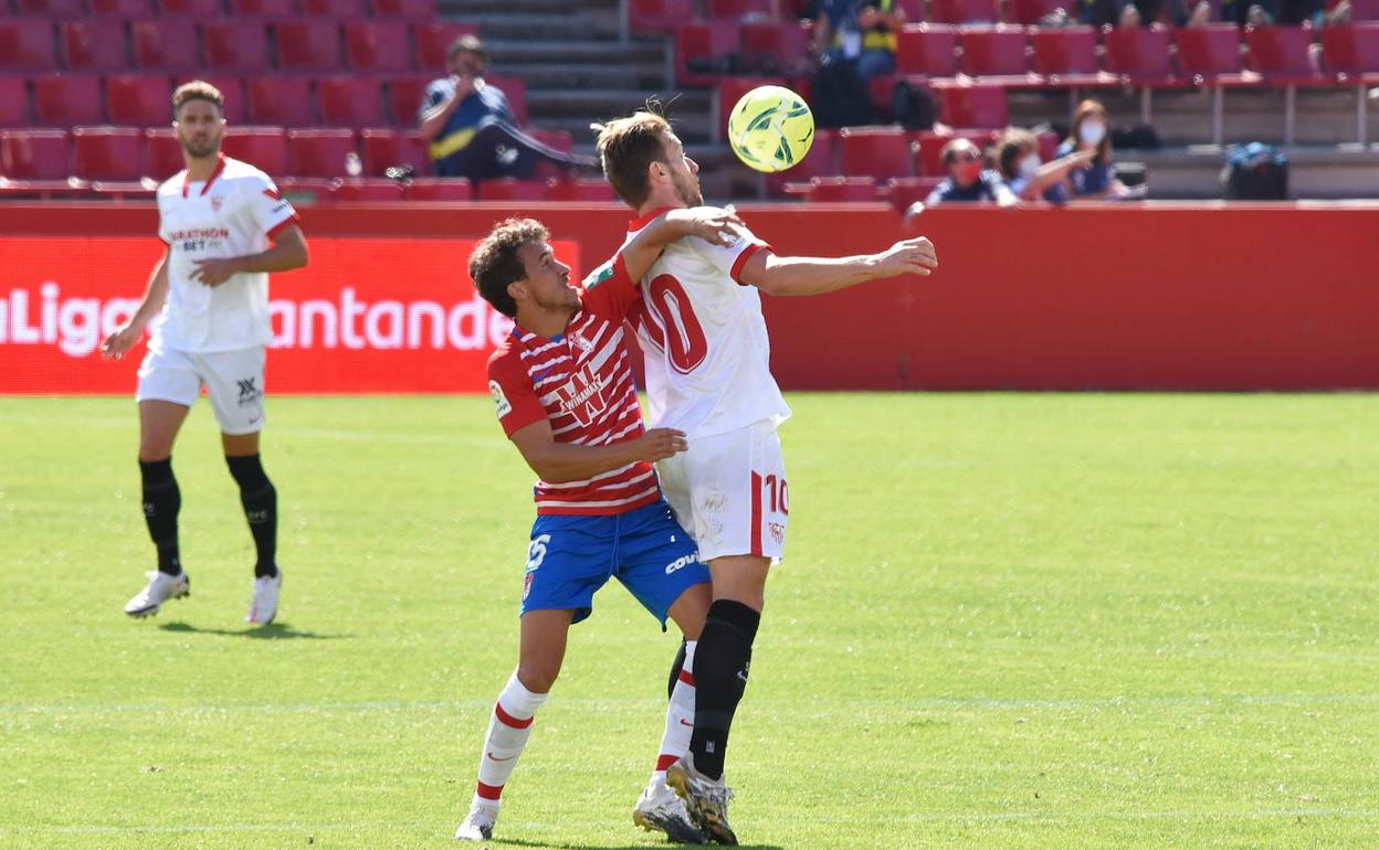 Luis Milla pelea la pelota con Ivan Rakitic en el partido ante el Sevilla en Los Cármenes.