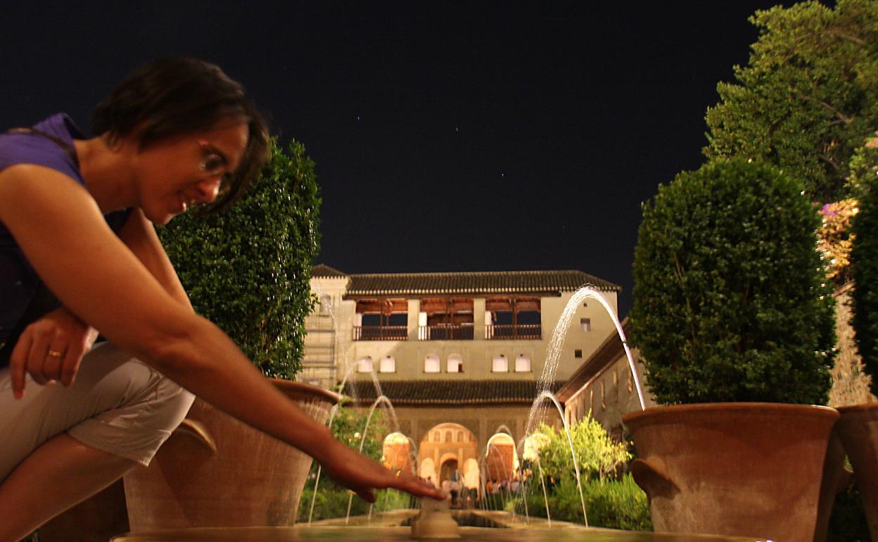 Una mujer, en el Generalife en una visita nocturna.