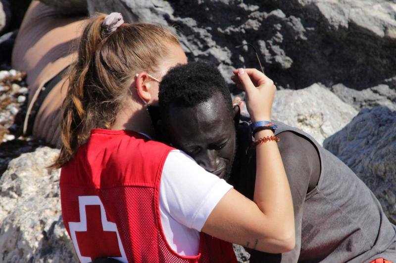 La voluntaria de Cruz Roja, Luna, abraza a un inmigrante en la playa de El Tarajal hace una semana.