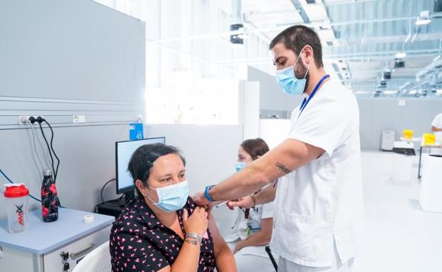 Un enfermero vacuna a una mujer