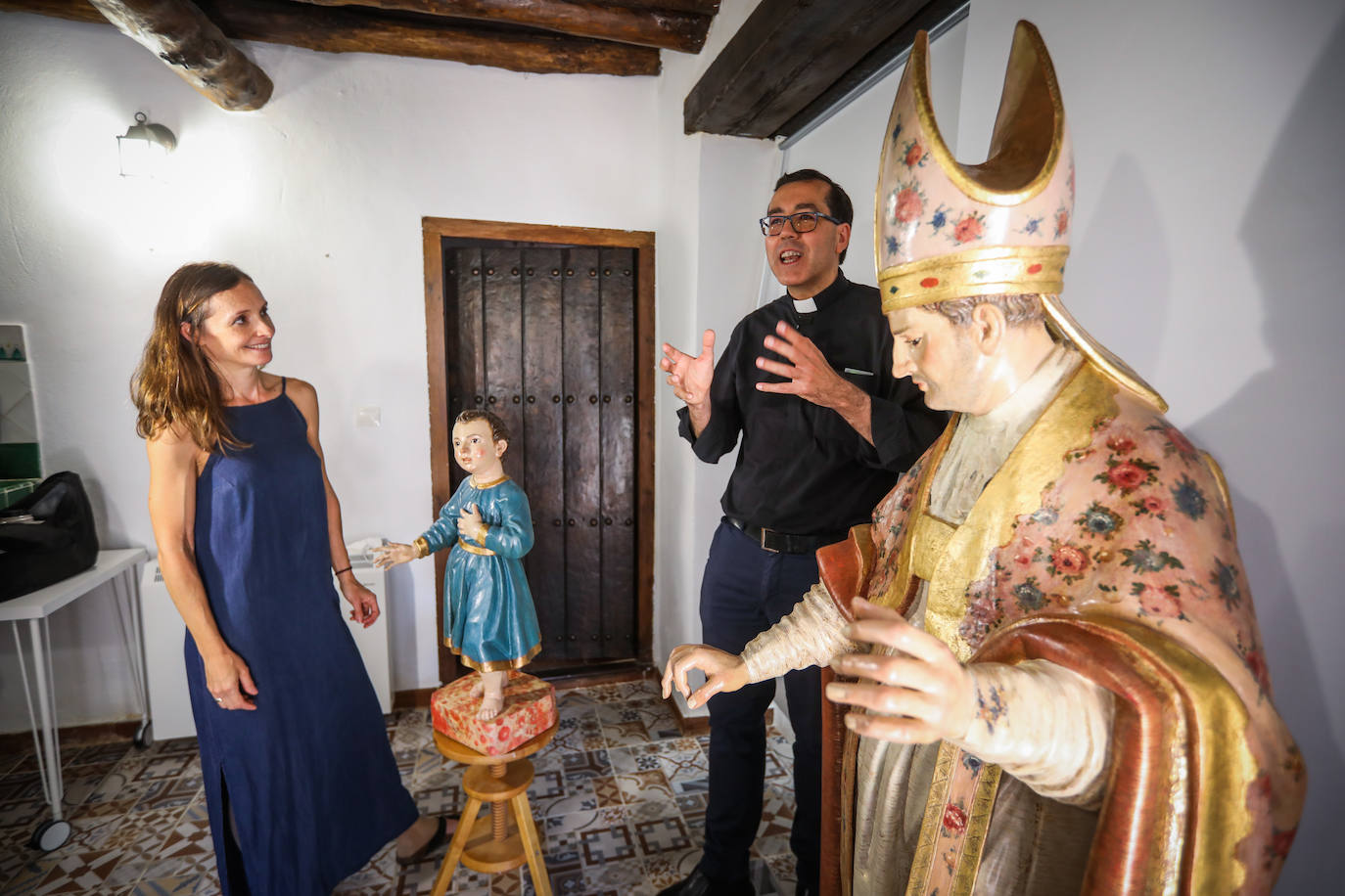 David Cuerva, párroco de Víznar, charla con Virgnia en su taller, junto a San Blas y el niño del milagro.