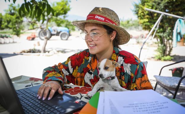 t Ana trabaja con el portátil en el patio de su casa, donde habitualmente se prepara los exámenes de la universidad.. 