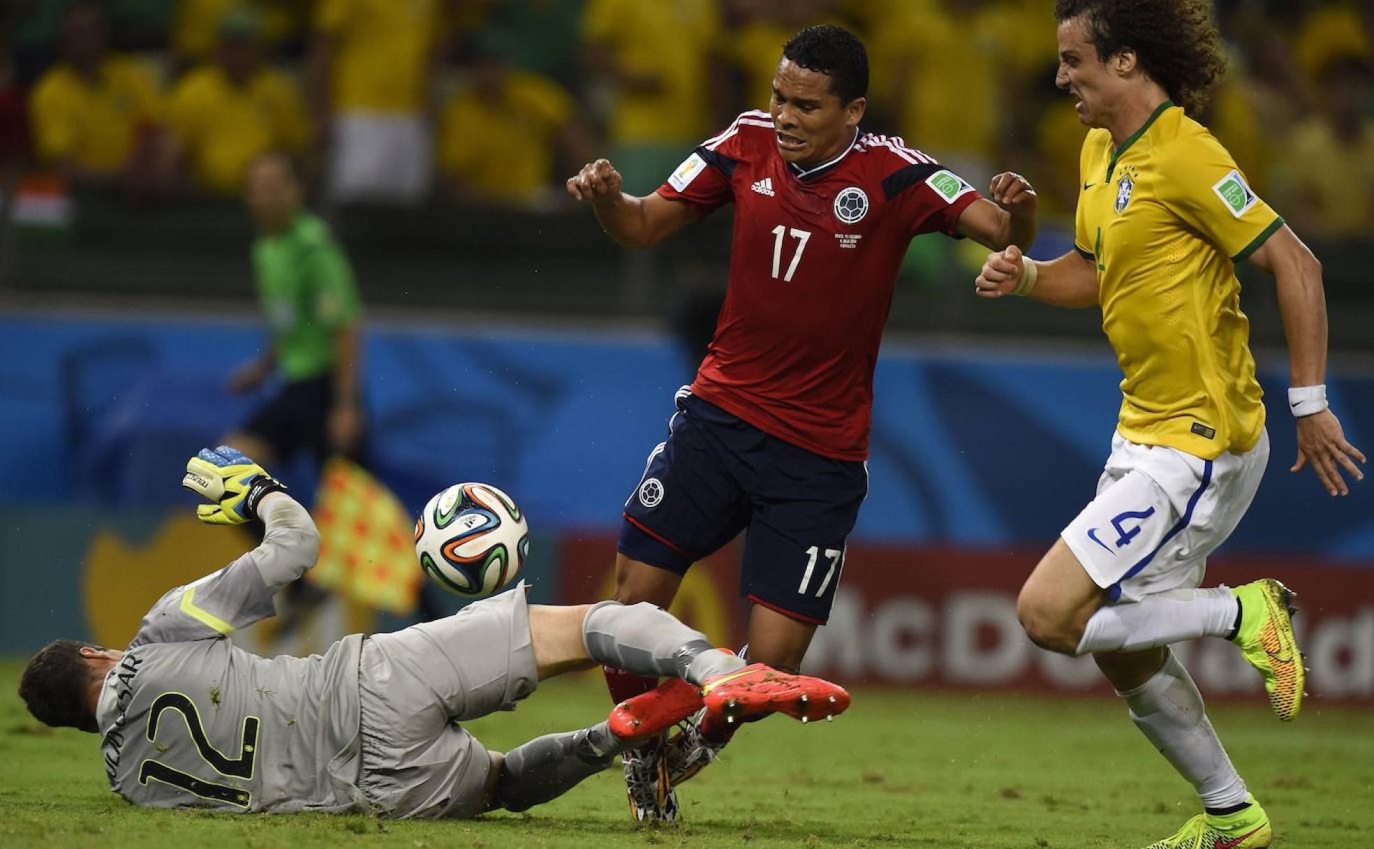 Carlos Bacca trata de salir victorioso de un balón dividido en un duelo con Colombia.