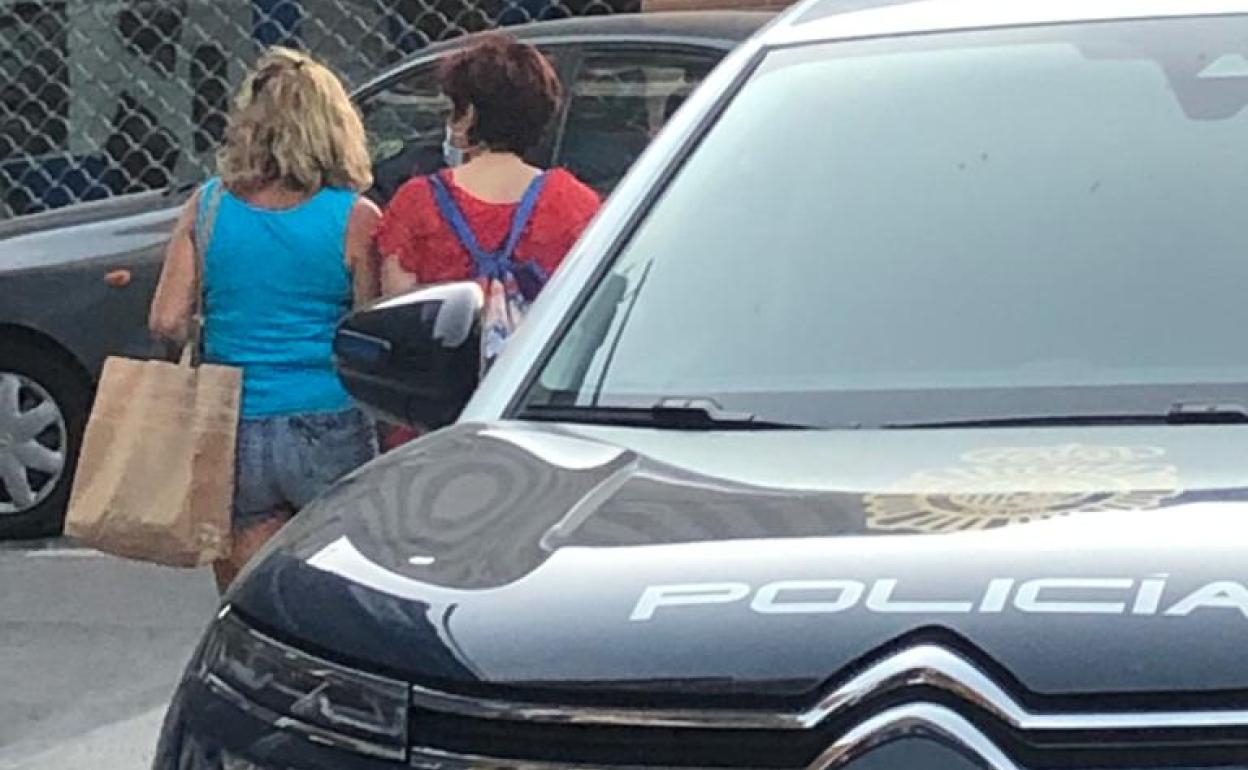Dos mujeres observan el despliegue policial en la calle Ledaña ayer por la tarde.