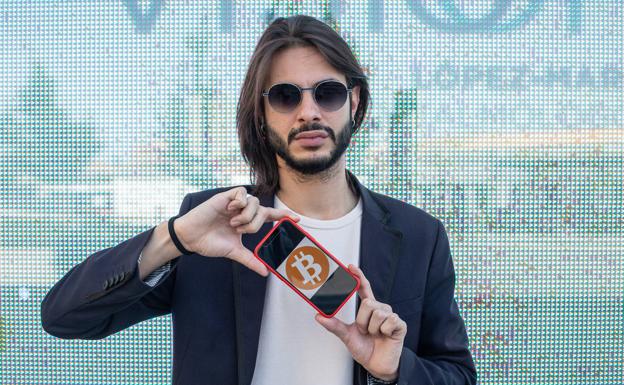 Miguel Gil, con el logo de Bitcoin en su móvil. 