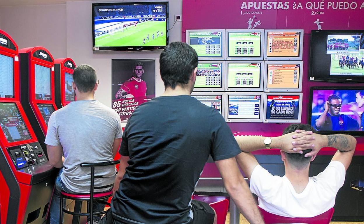 Enganchados. Jugadores siguen retransmisiones deportivas en una casa de apuestas.