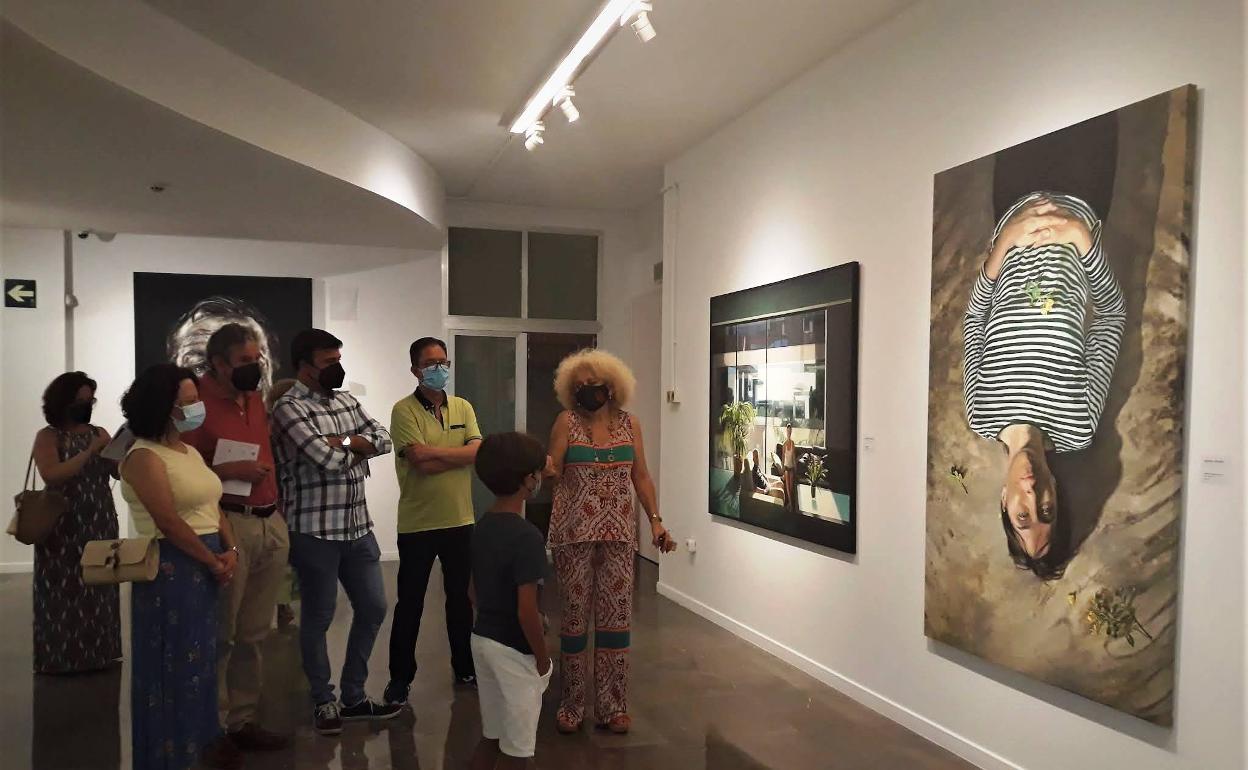 Visitantes de la exposición admiran el cuadro ganador del certamen. 