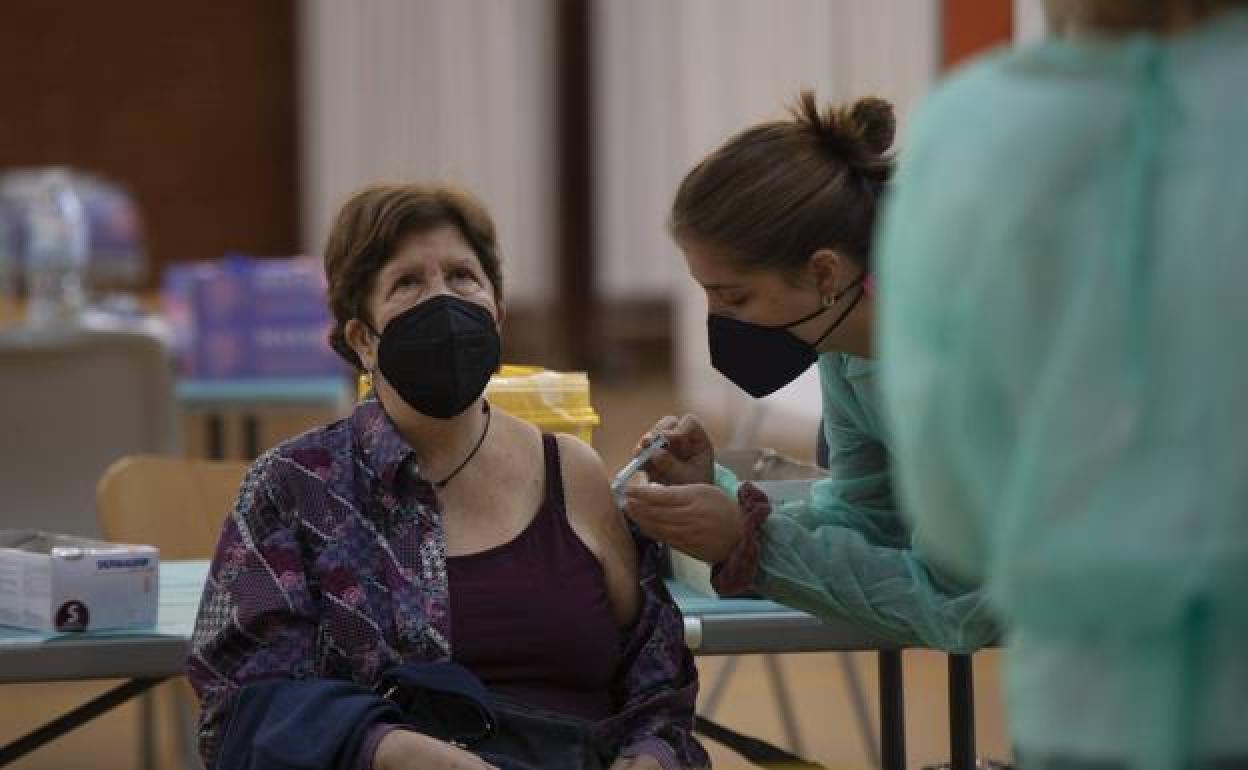 Una mujer recibe una dosis de la vacuna frente a la covid-19 en un punto de vacunación.