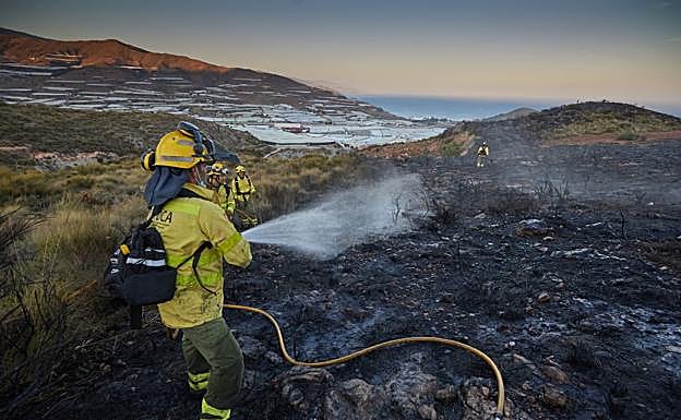 Un efectivo del Infoca enfría una zona donde ya se han extinguido las llamas en el incendio de Gualchos-Castell.