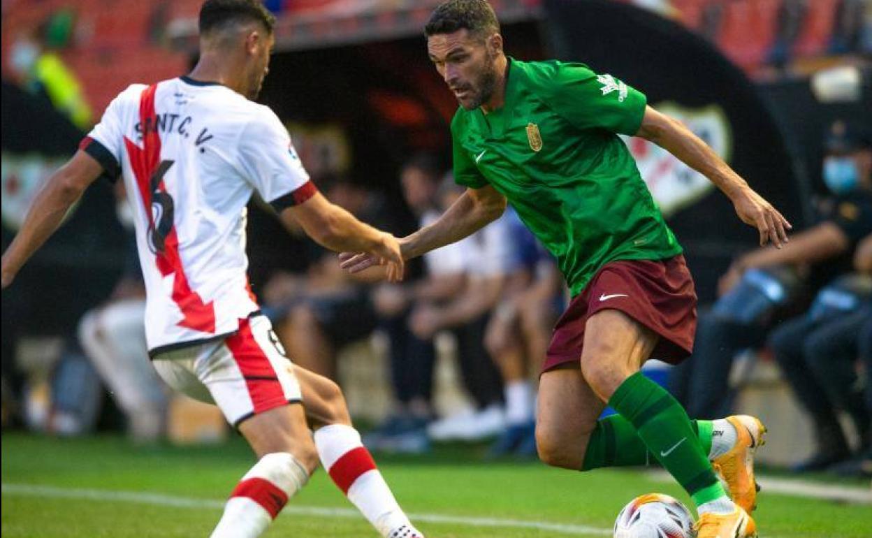 Jorge Molina retiene un balón ante Santi Comesaña en Vallecas. 