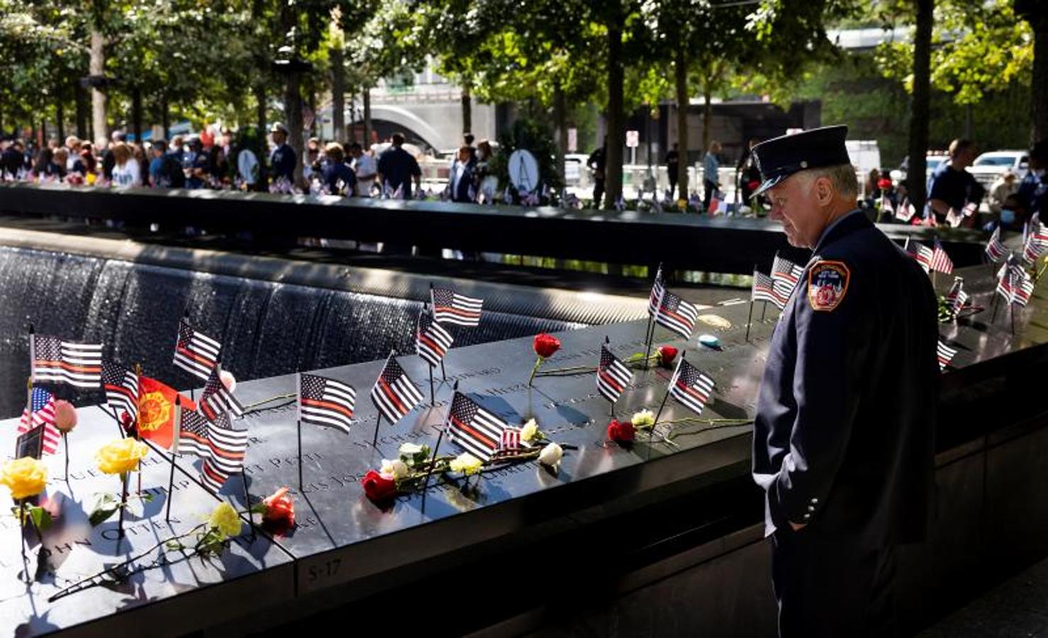 Un bombero rinde homenaje a los compañeros fallecidos en el altar levantado en su recuerdo.