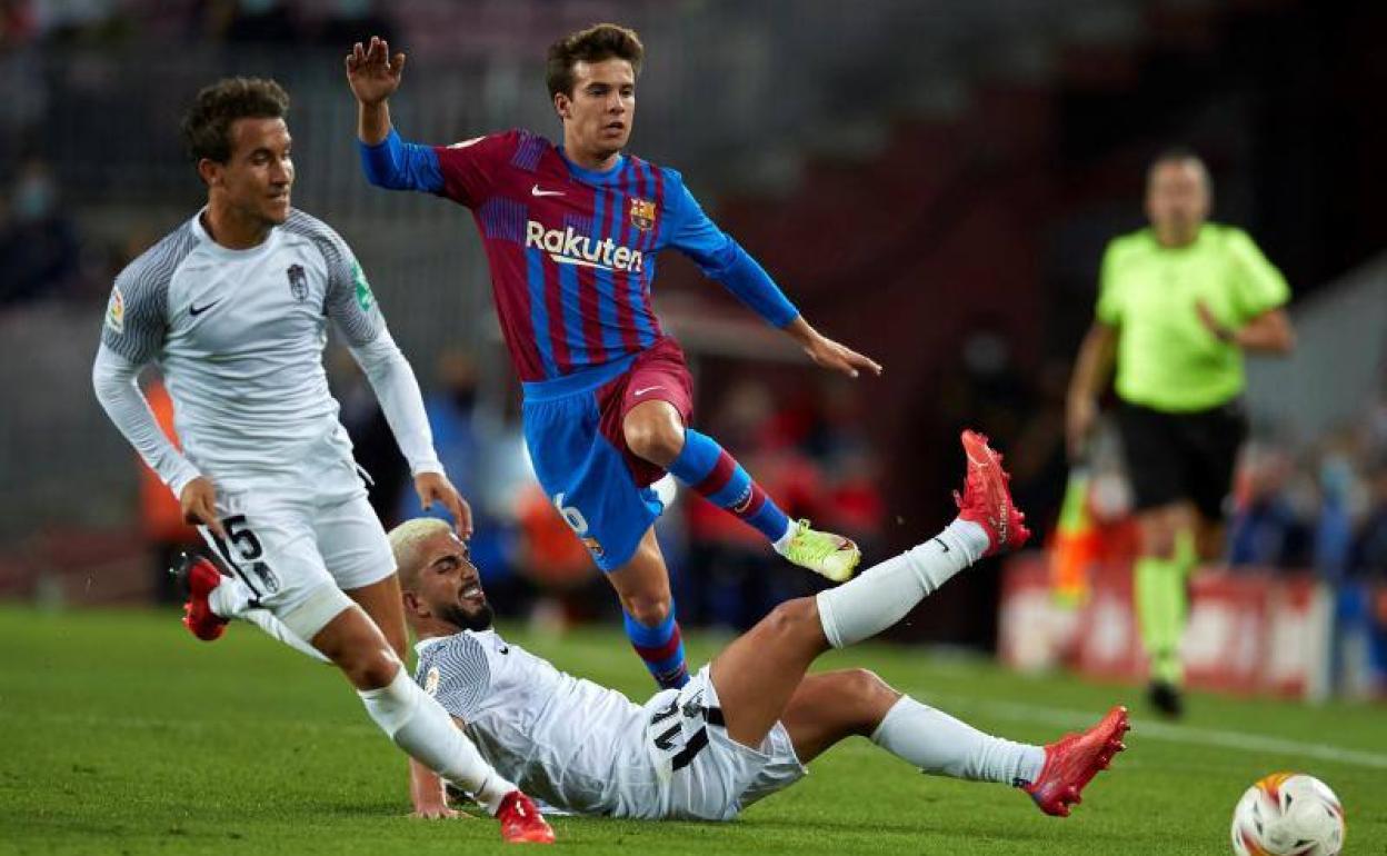 Monchu Rodríguez y Luis Milla tratan de frenar un ataque de Riqui Puig. 