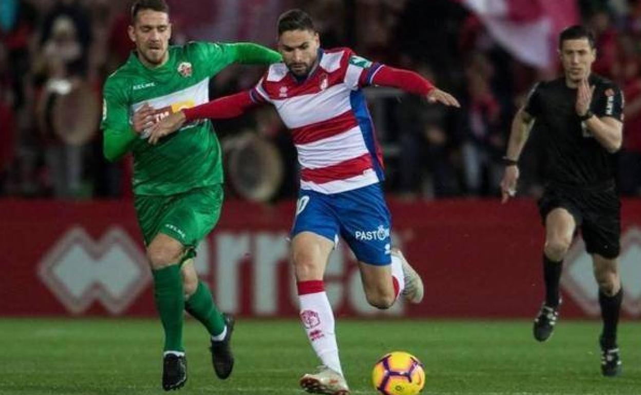 Soto Grado corre detrás de Antonio Puertas en un Granada-Elche disputado en Los Cármenes. 