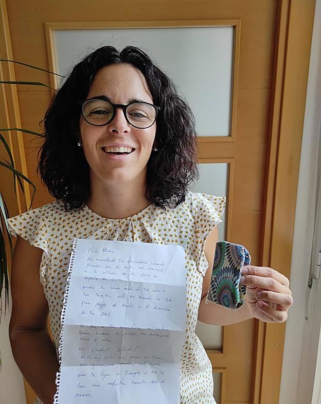 María Frasquet posa sonriente con su monedero recuperado y la carta que recibió. 