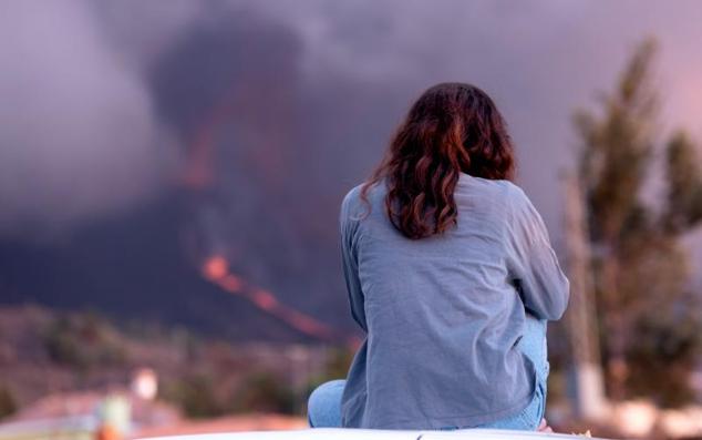 Una mujer observa el volcán de La Palma donde se aprecian dos nuevas bocas eruptivas.