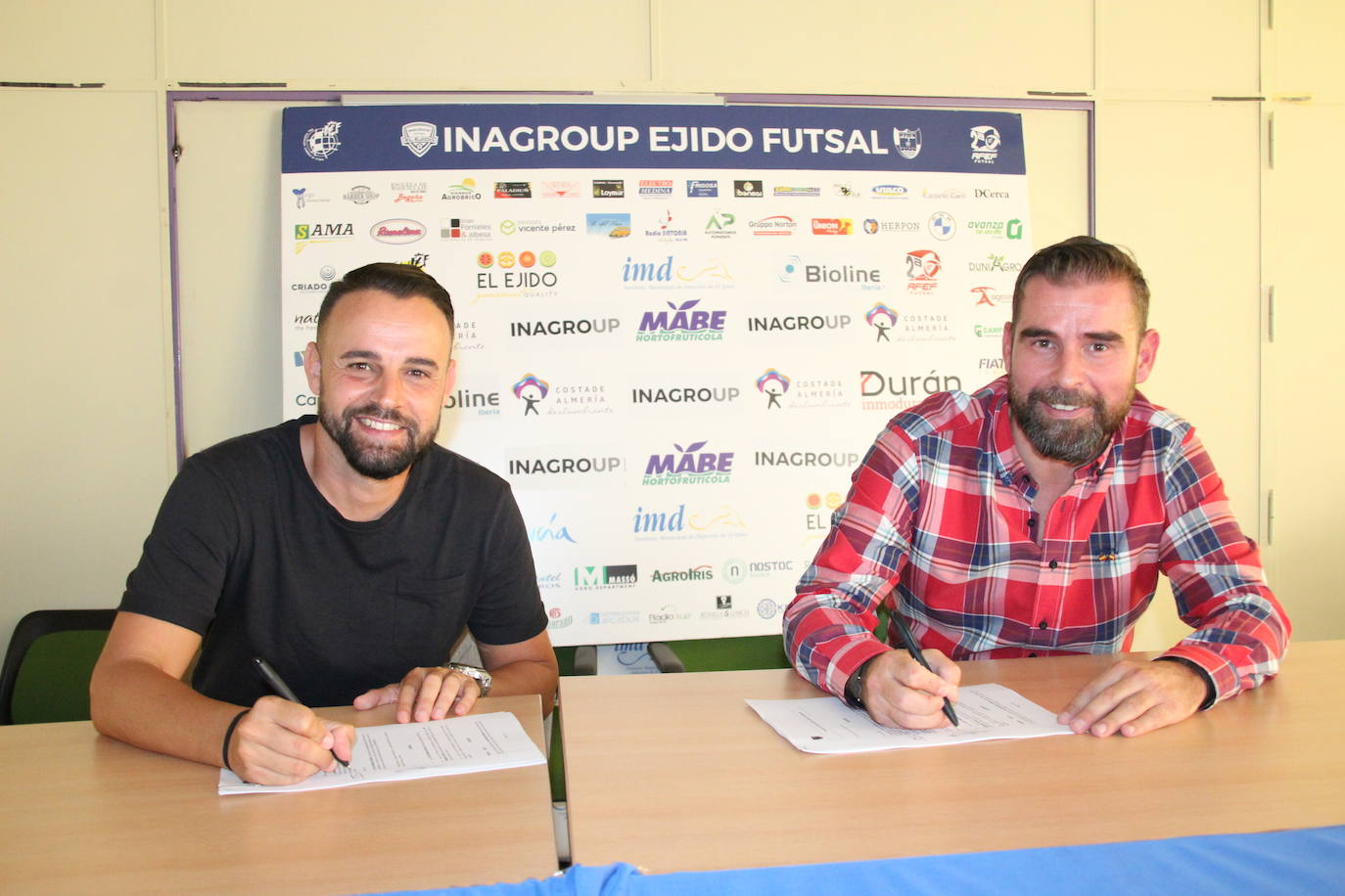 El entrenador catalán, firmando su nuevo contrato junto a Miguel Brugarolas. 