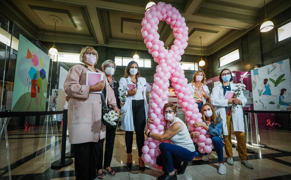 Pacientes y sanitarias posan todas juntas en torno a un enorme lazo de color rosa el Día Mundial del Cáncer de Mama, en el hospital Virgen de las Nieves.