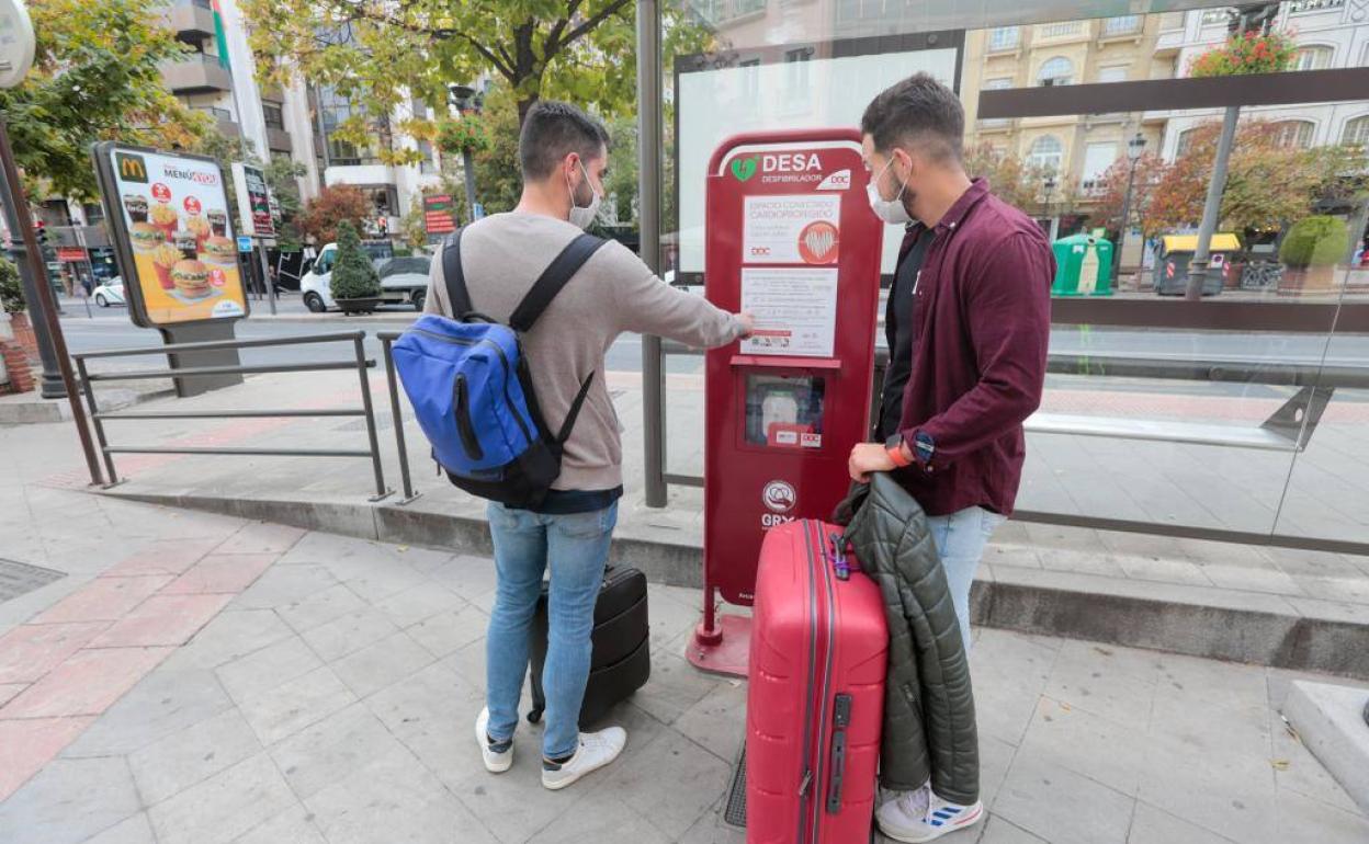 Dos jóvenes observan el desfibrilador que le salvó la vida al hombre el pasado sábado.